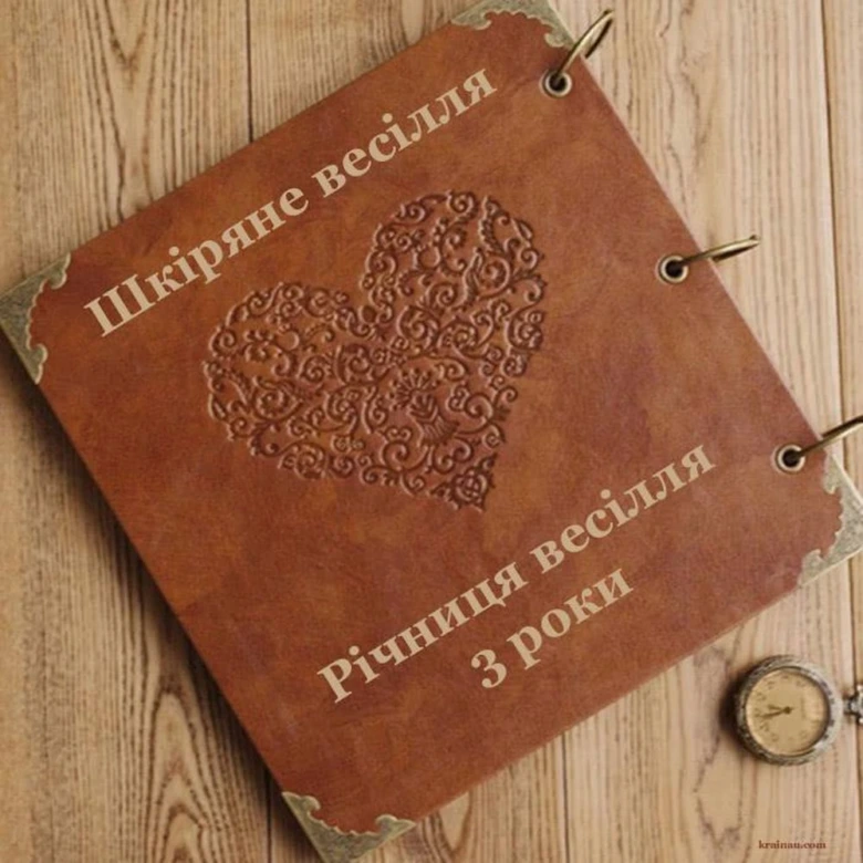 Коричневий шкіряний альбом з гравіюванням серця та привітаннями до третьої річниці весілля.