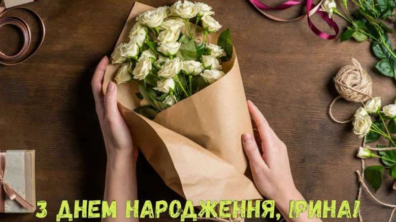 Букет білих троянд у руках з привітанням Ірині.