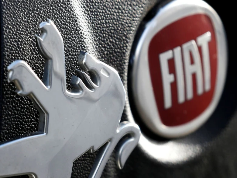 Логотипи Peugeot та Fiat на решітці радіатора автомобіля