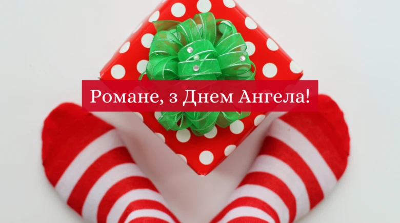 Червона подарункова коробка з зеленим бантом та привітання Роману.
