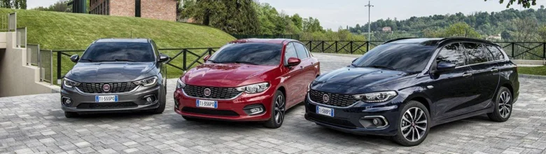 Три автомобілі Fiat різних моделей на фоні природи.